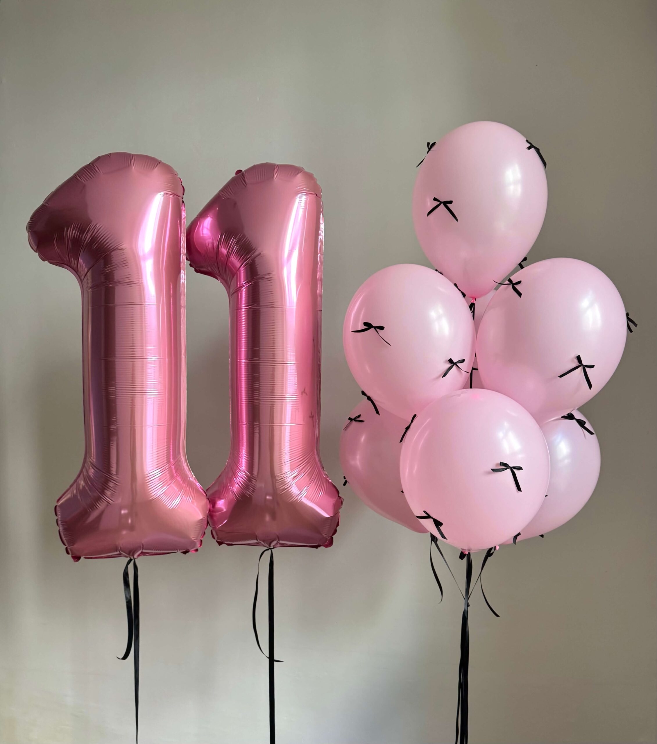 Композиция на 11 лет для девочки с розовыми фольгированными цифрами 11 и розовыми воздушными шарами с черными бантиками