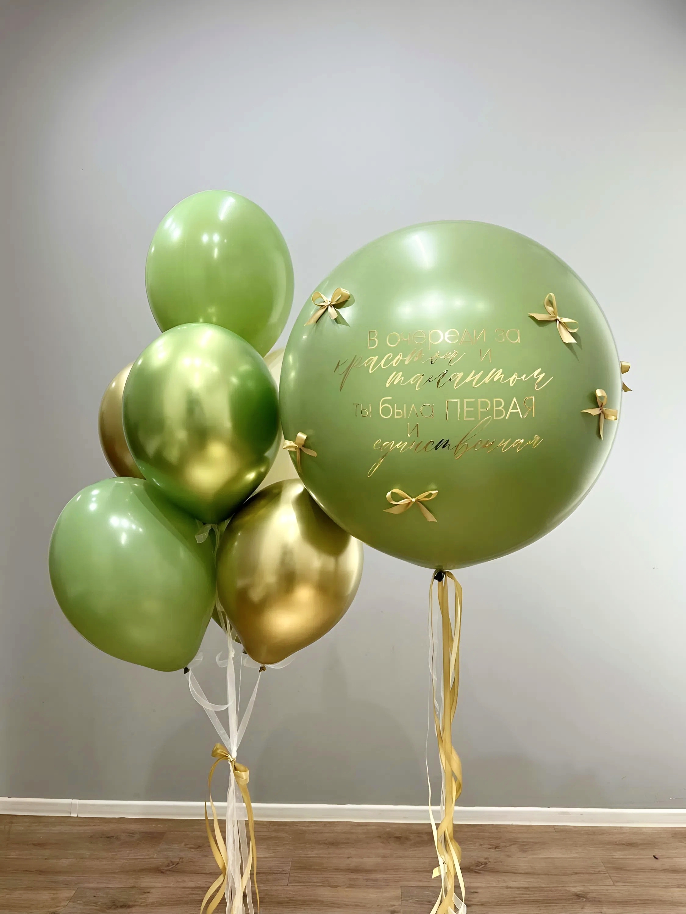 Композиция для девочки с большим зелёным Bubble с золотой надписью и бантиками, зелёными и золотыми воздушными шарами
